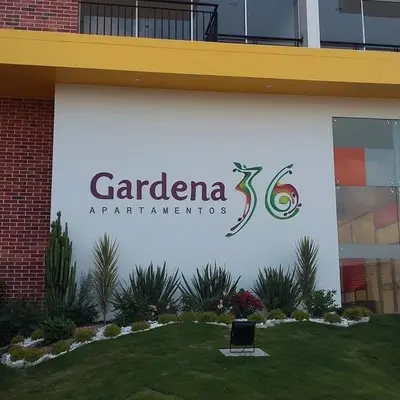 Pared exterior con el logotipo de Gardena 36 y una zona de césped.