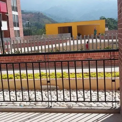 Vista desde el balcón privado de un apartamento hacia las zonas comunes y jardines.