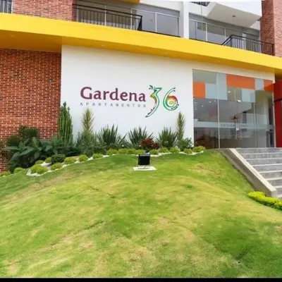 Vista panorámica exterior de la entrada principal, zona verde y sala de ventas.