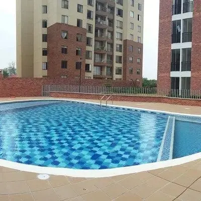 Piscina del conjunto residencial rodeada de rejas de seguridad y edificios.